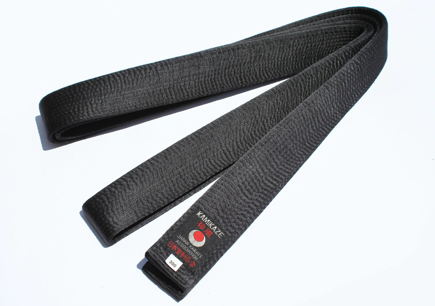 Black karate belt with stitched texture and Kamikaze embroidery on a white background